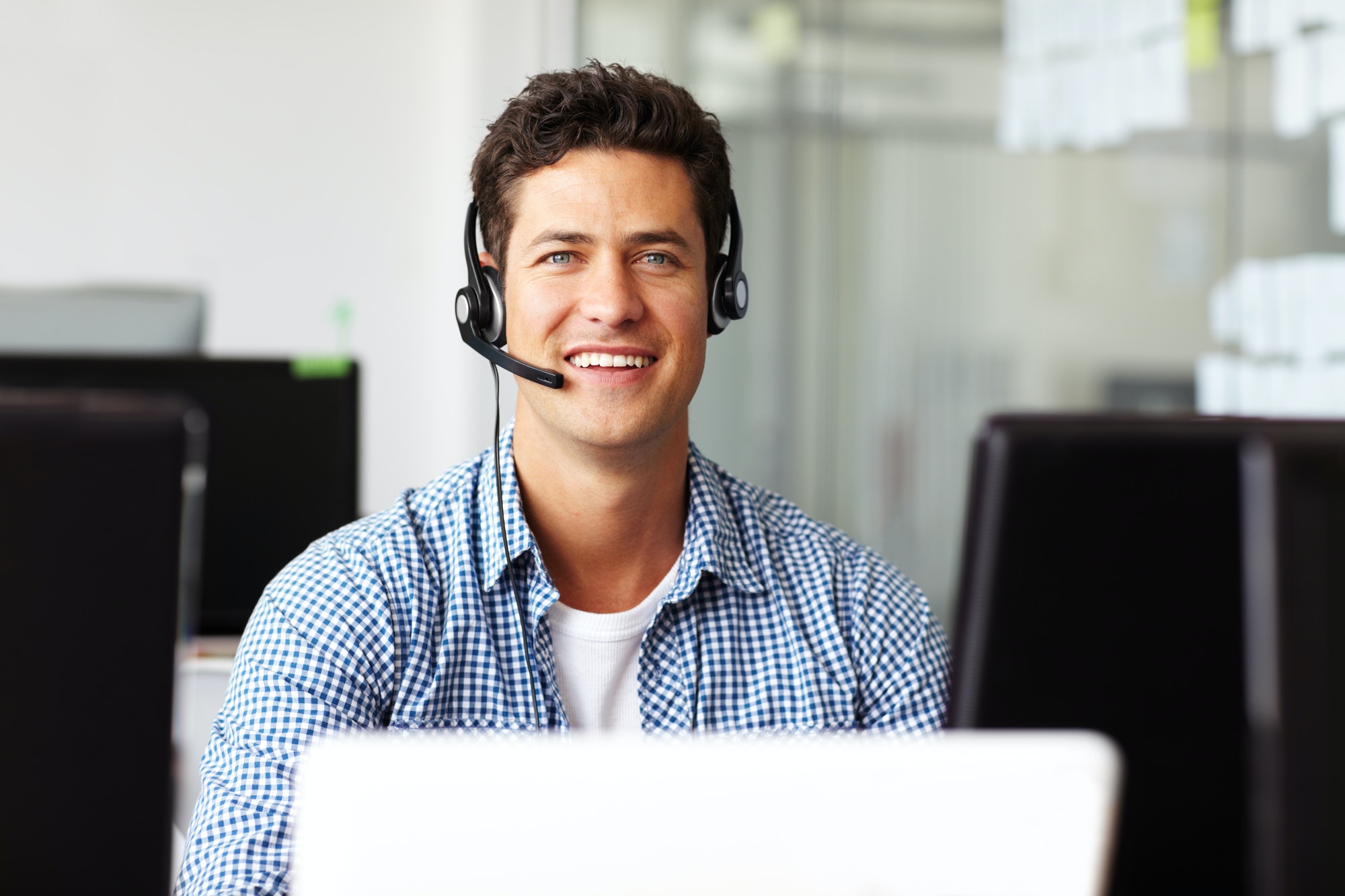 A handsome young telecommunications operative sitting at his desk