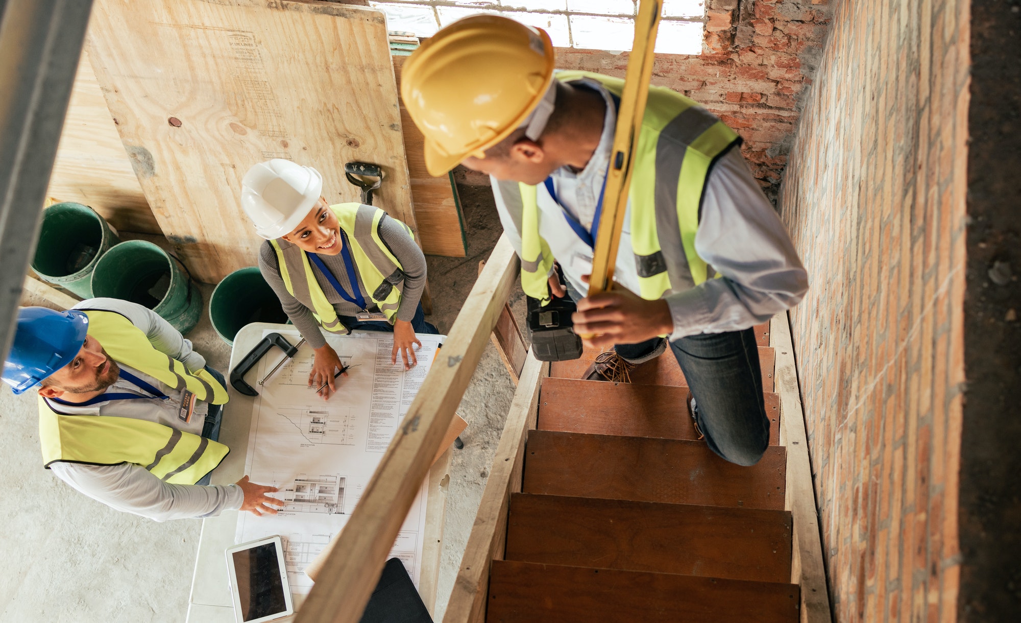 Top view, construction building and team planning with blueprint, collaboration and conversation. A